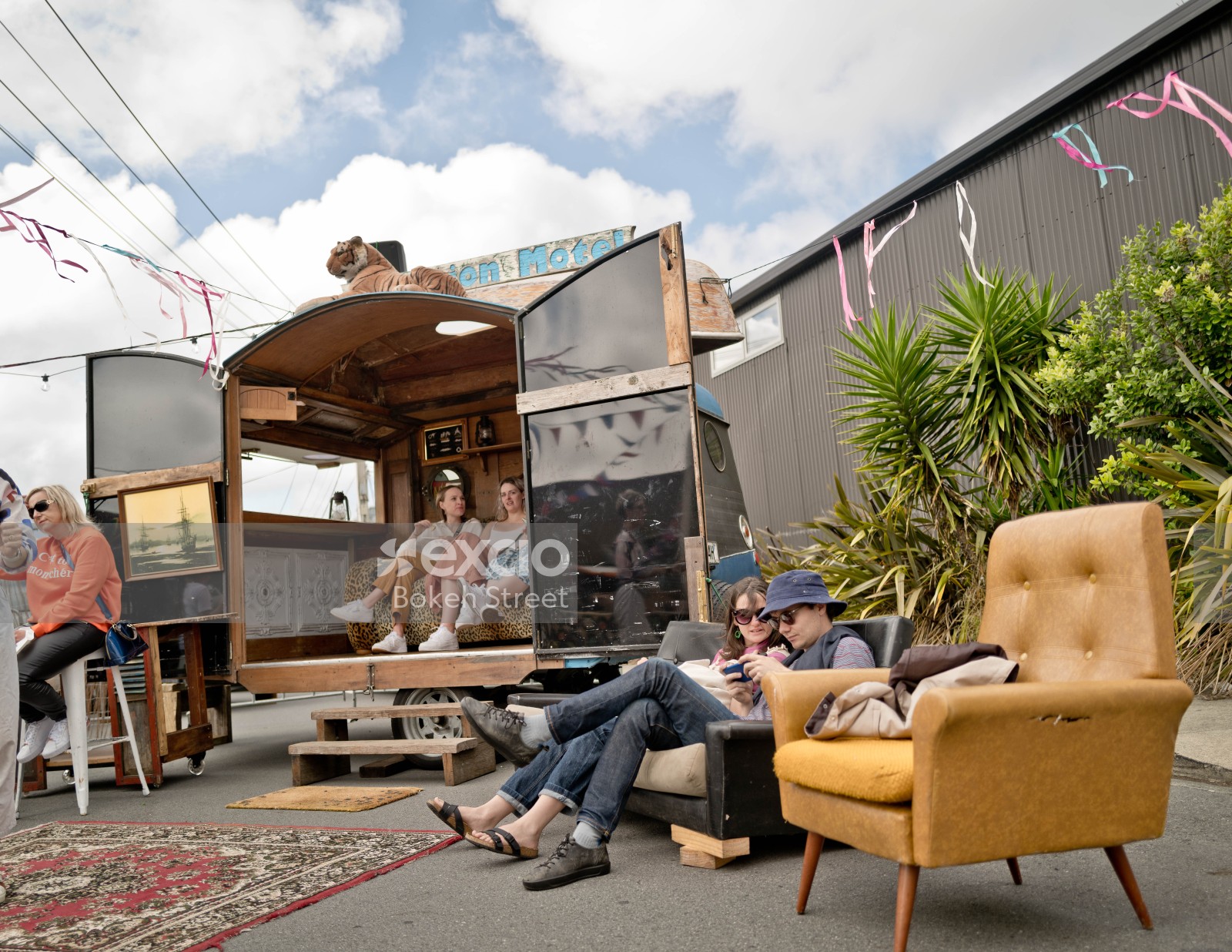 People sitting in and around a caravan at Newtown festival 2021