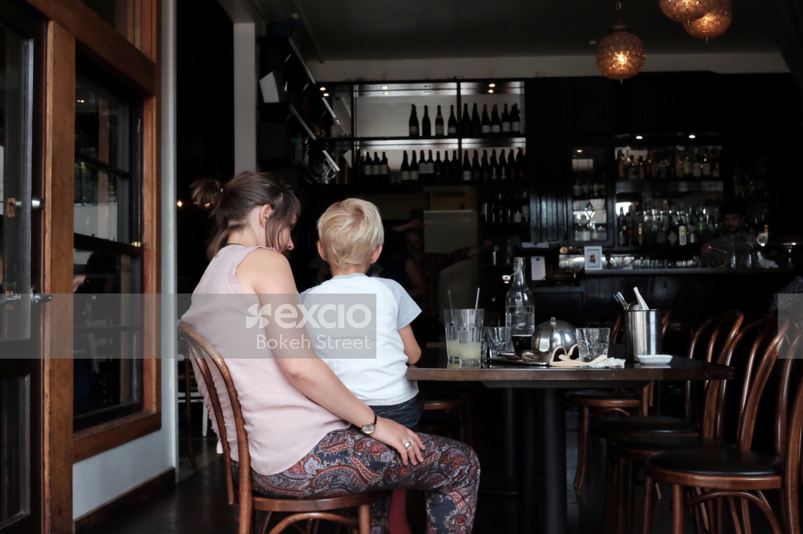 A young boy in a woman's lap at a restaurant in downtown Wellington