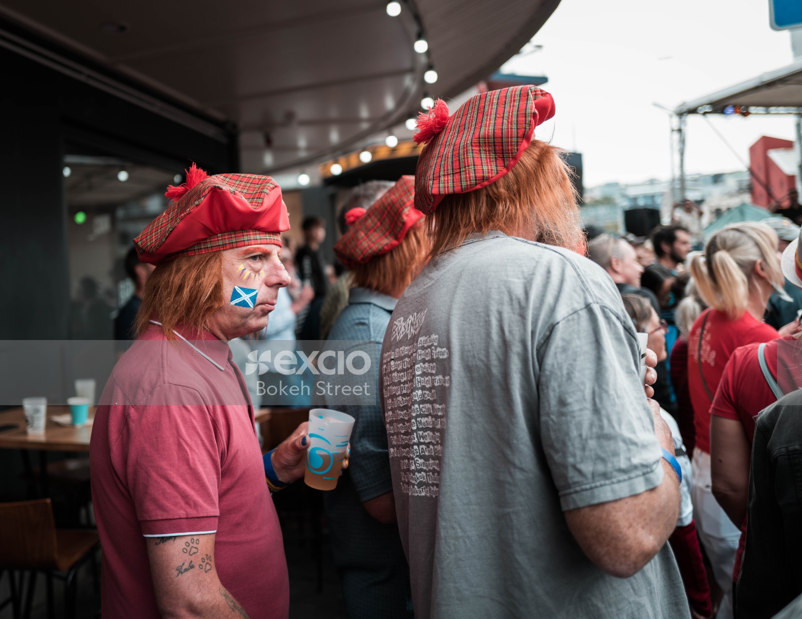 Men wearing Scottish caps and face paint flag 