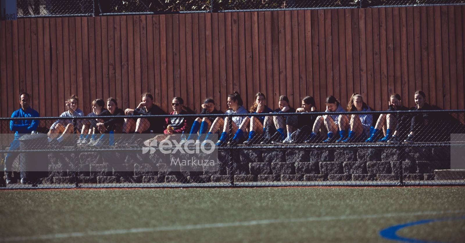 Female players sitting outside the field watching football match - Sports Zone sunday league