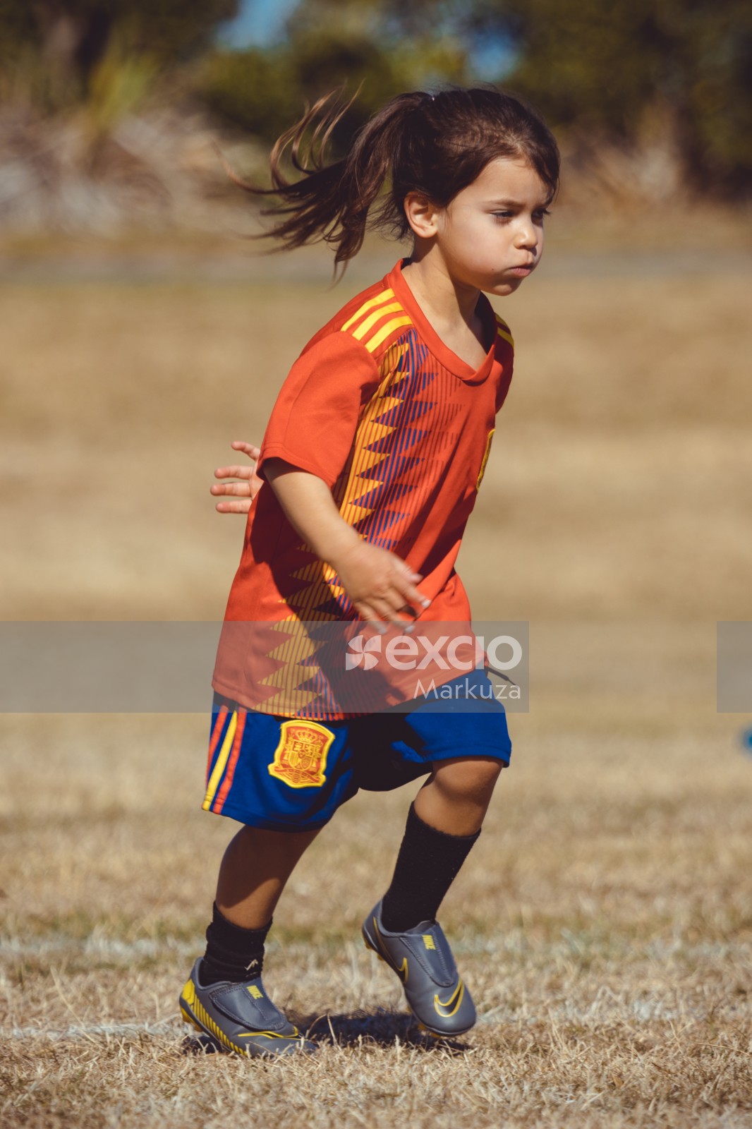 Girl in Manchester United kit and ponytail running - Little Dribblers