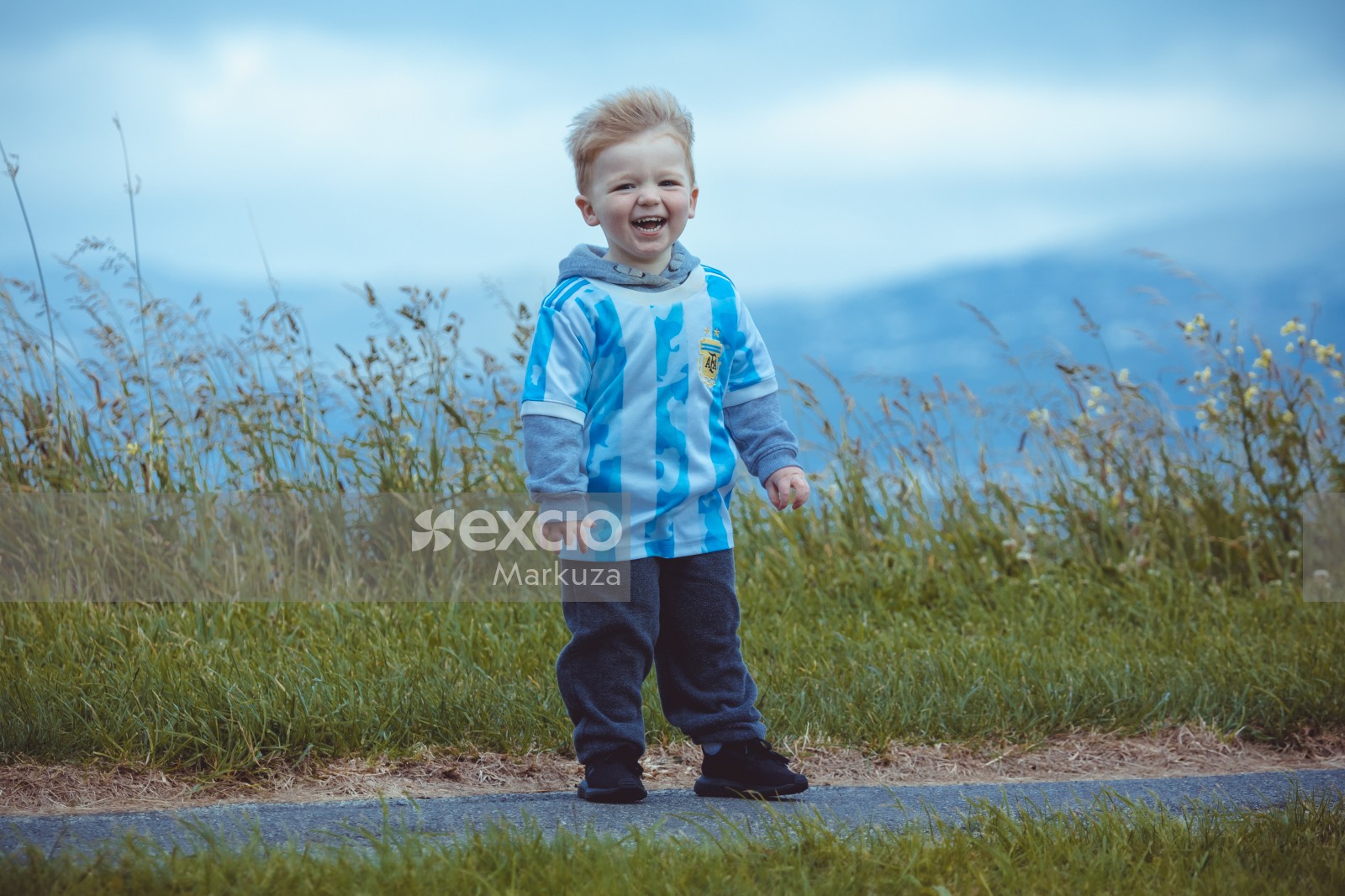 Laughing blonde haired boy wearing Argentine jersey - Little Dribblers