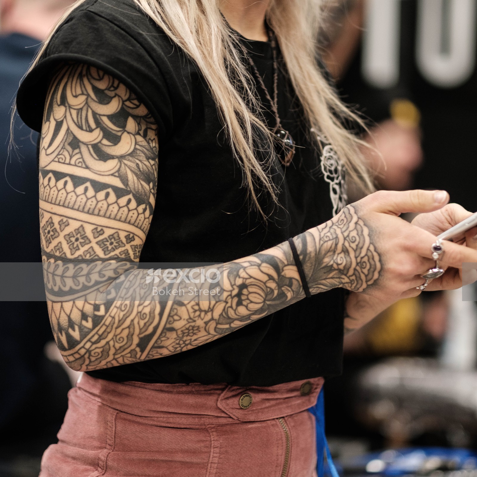Tattooed arm of a woman wearing pink pants