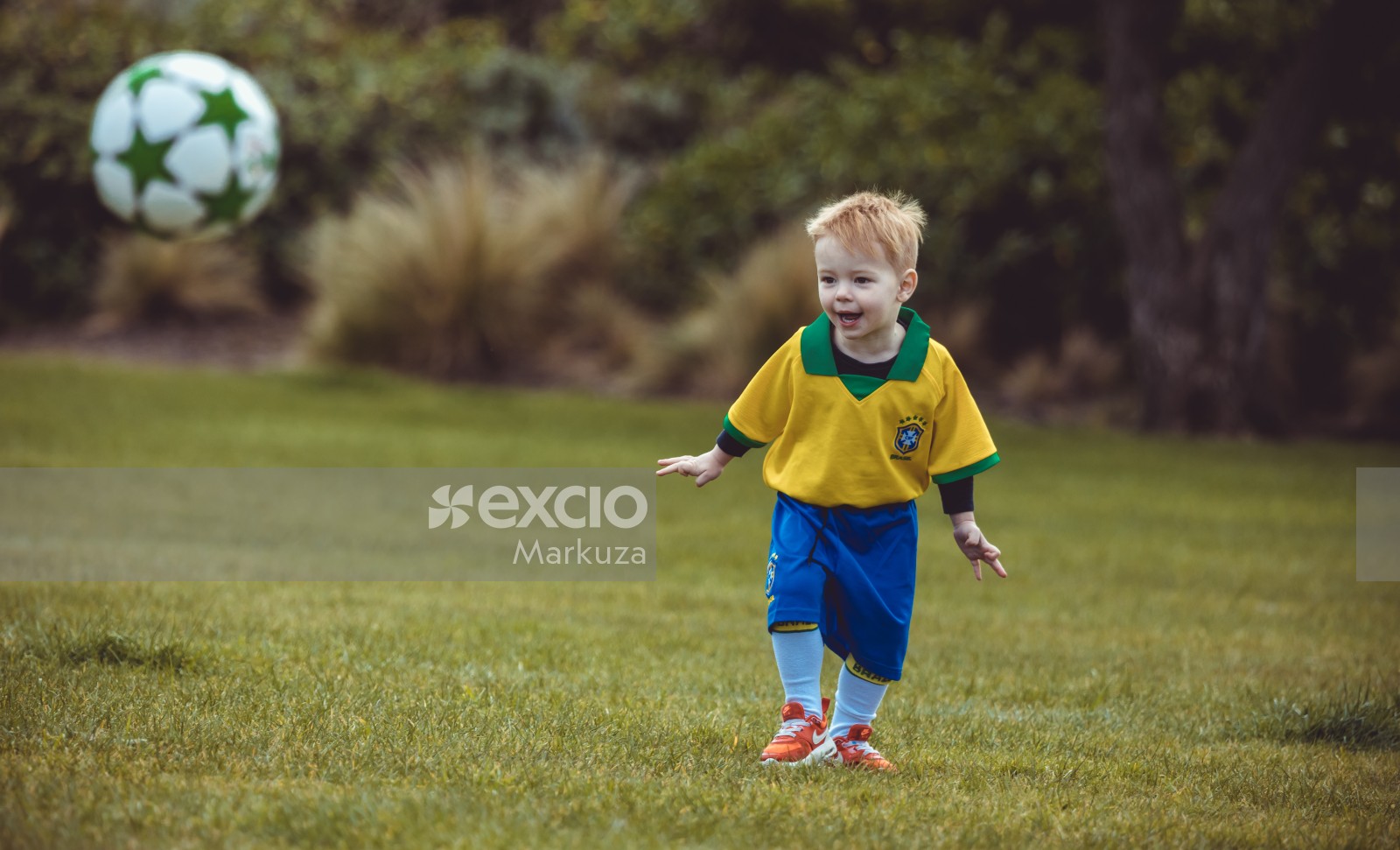Boy excitedly looking at bouncing football - Little Dribblers