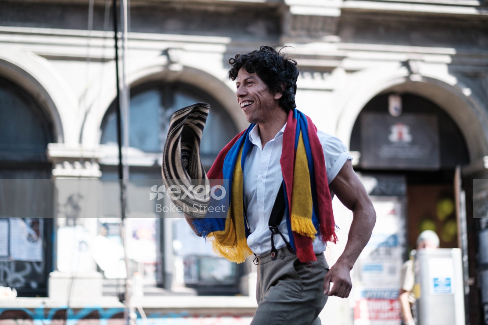 Cheerful man with a multicoloured scarf dancing at Cuba Dupa 2021 bokeh