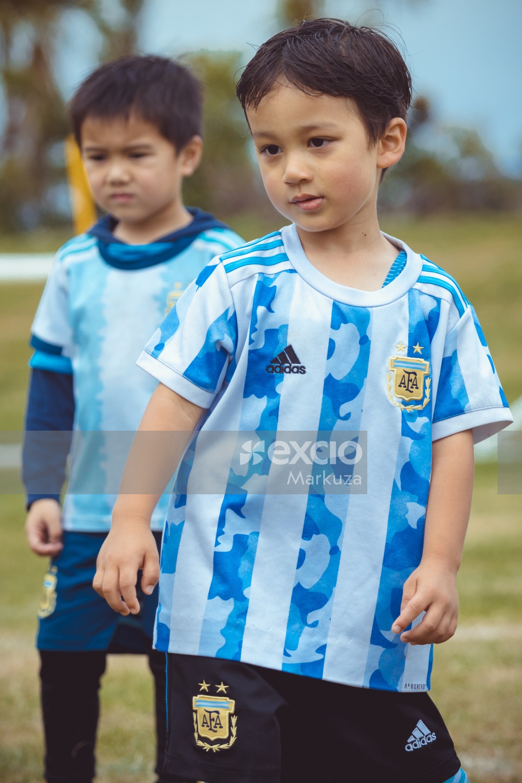 Little football player standing in front of second boy bokeh - Little Dribblers