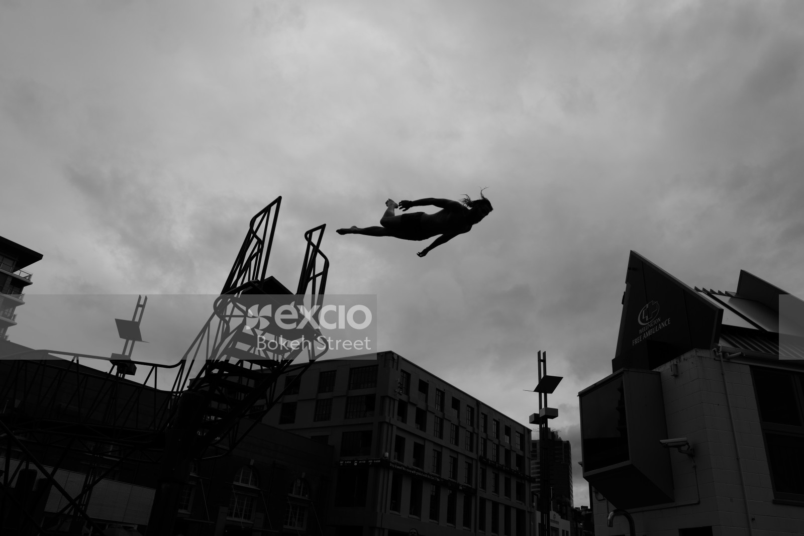 Silhouette of a man diving from a platform black and white