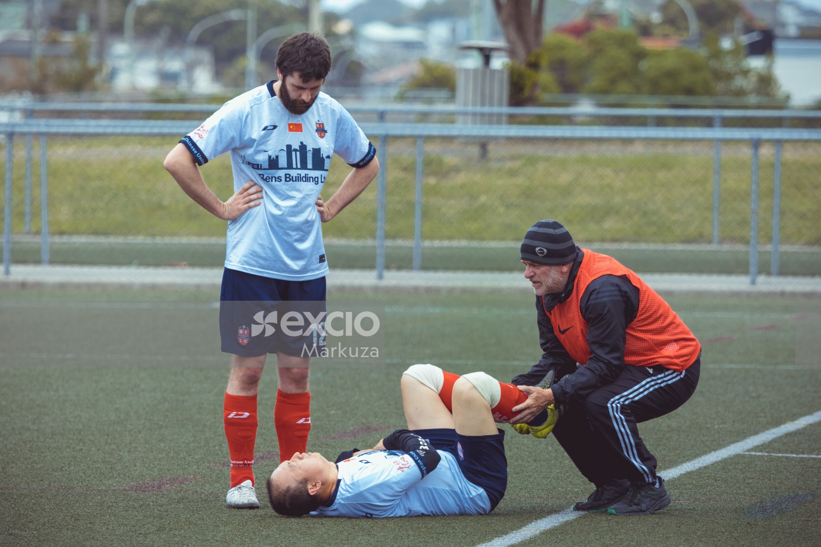 Referee tending to an injured player on the ground - Sports Zone sunday league