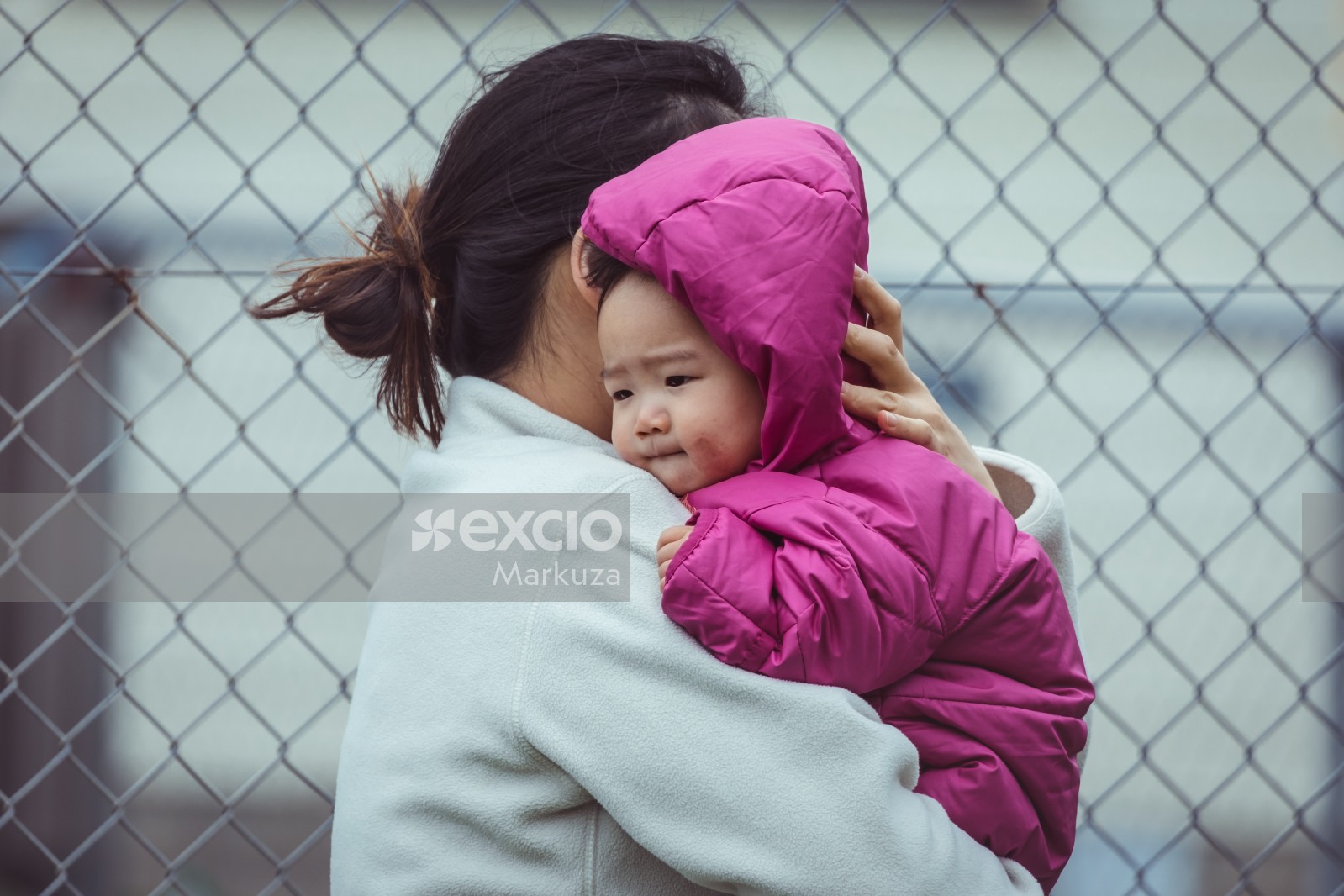 Mother carrying a baby in pink jacket