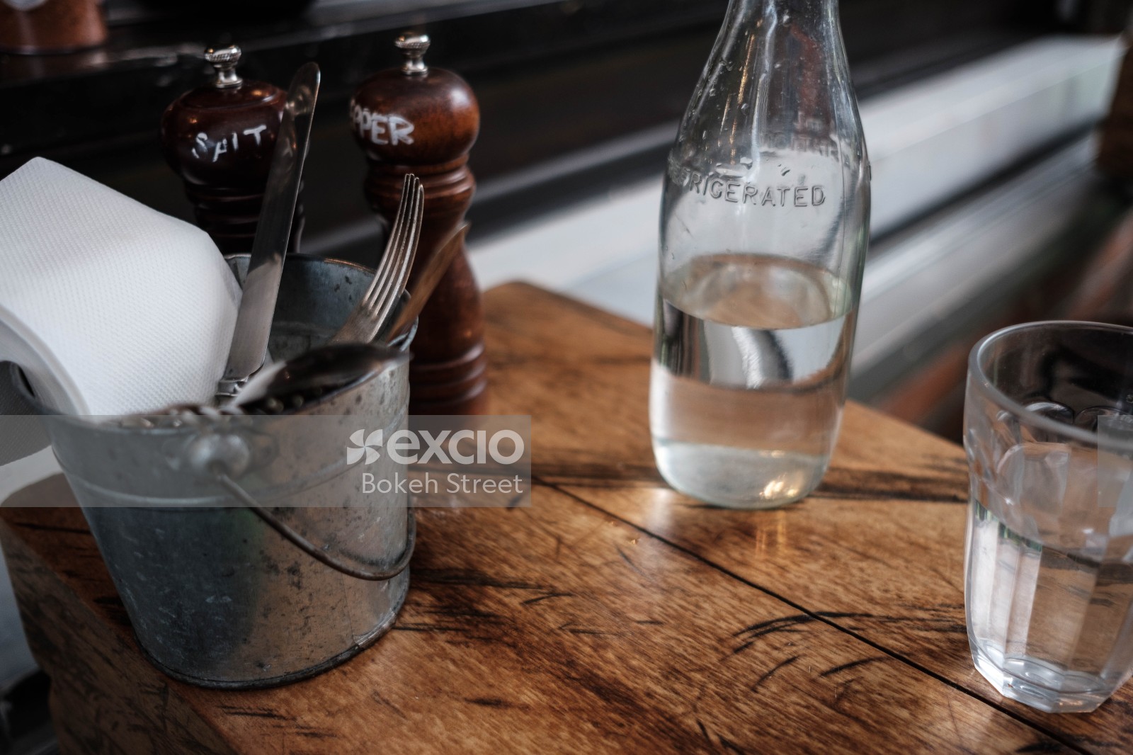 Cutlery salt and pepper container bottle and glass at a cafe
