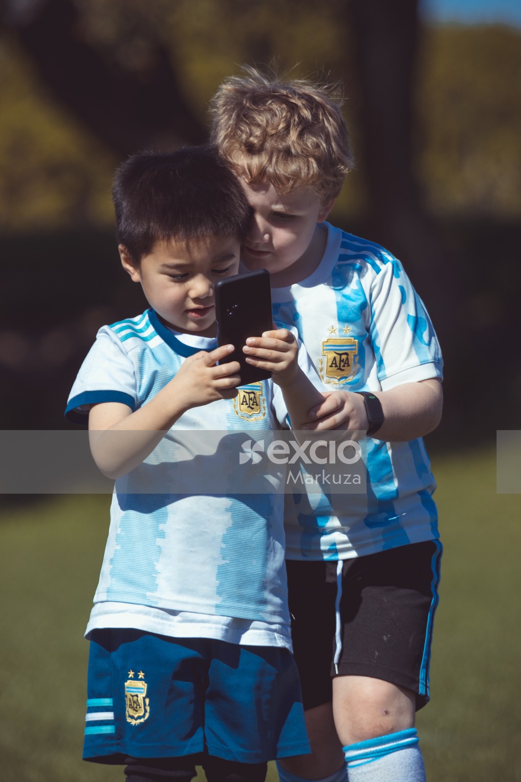 Kid teammates looking at mobile phone 
