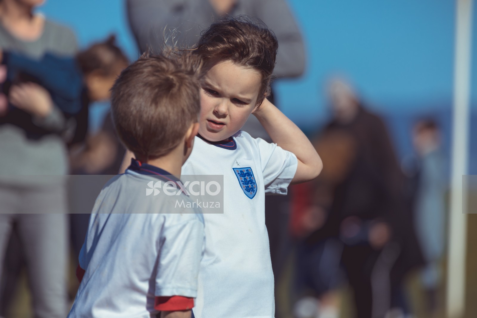 Little kids in white kit at a football match