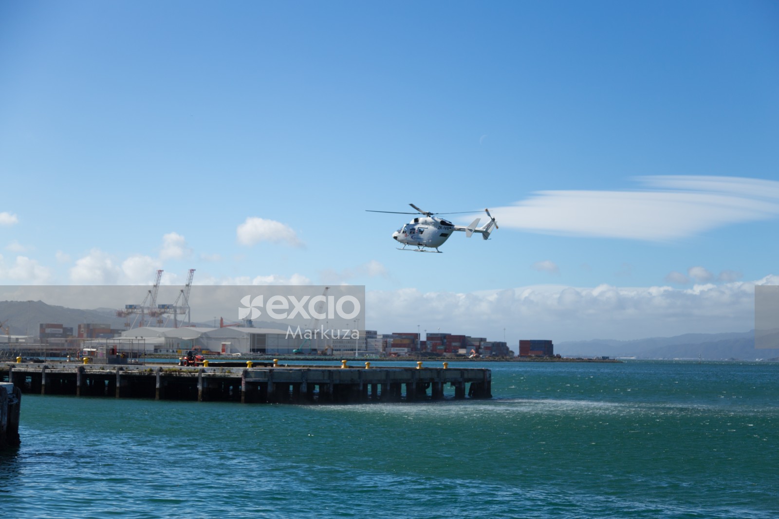 White helicopter landing on the harbour