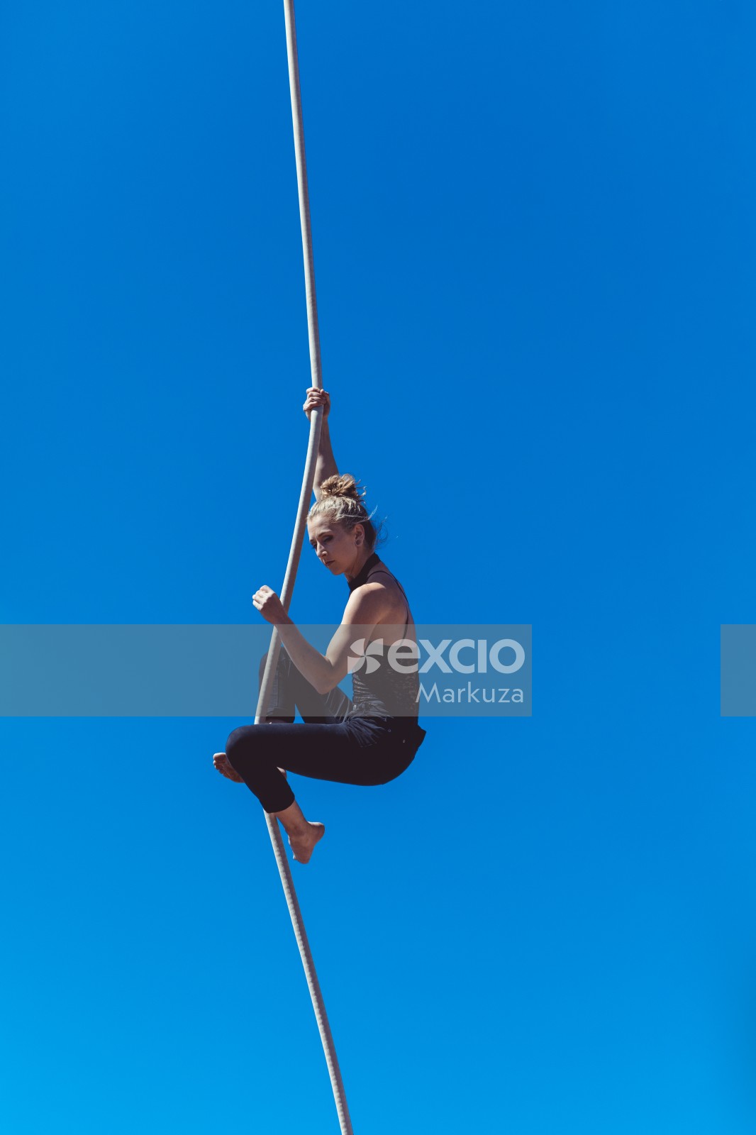 Woman hanging from a rope and clear blue sky