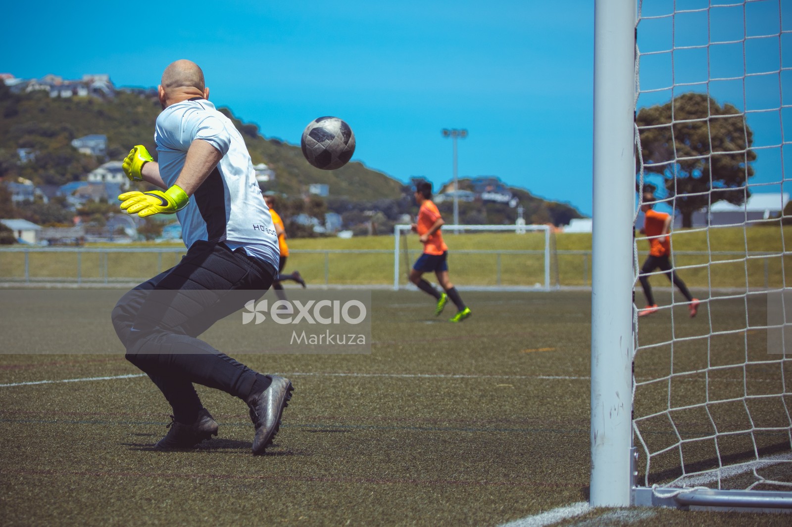 Goalkeeper wearing neon yellow Nike gloves and an incoming ball - Sports Zone sunday league