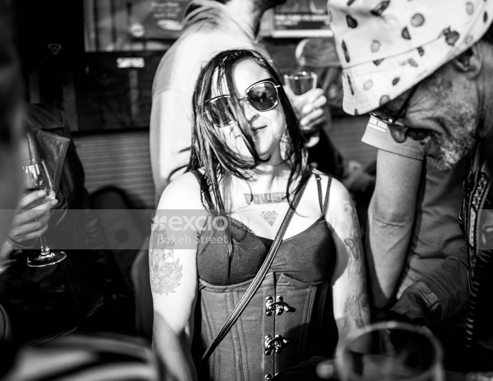 Tattooed woman wearing a corset and shades at Newtown festival 2021 monochrome