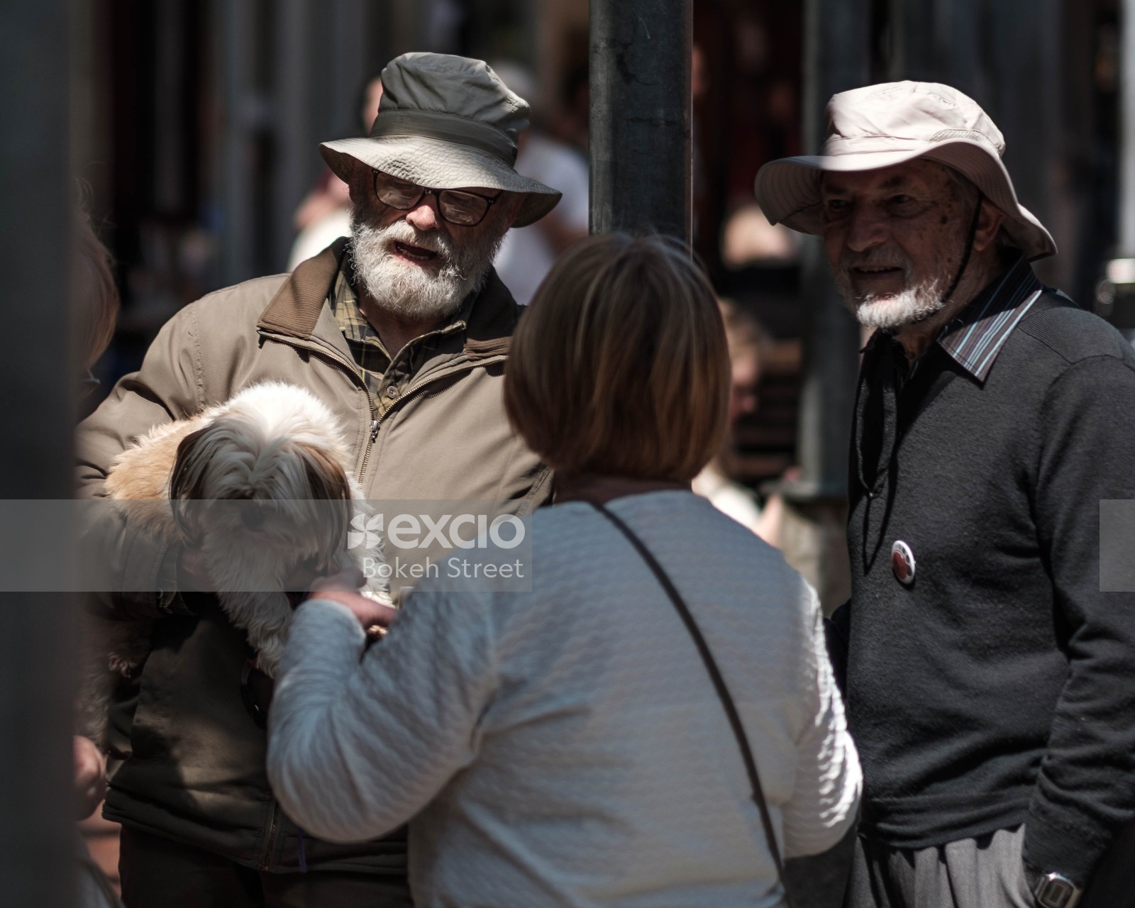 Woman talking to a man carrying a small dog