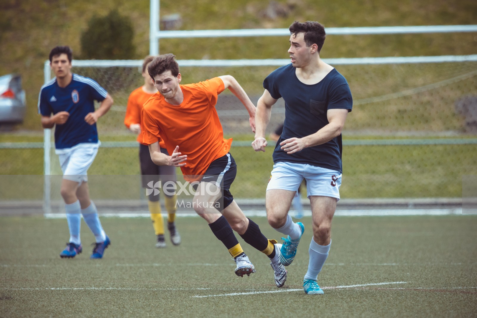 Football players dashing in orange and black shirts - Sports Zone sunday league