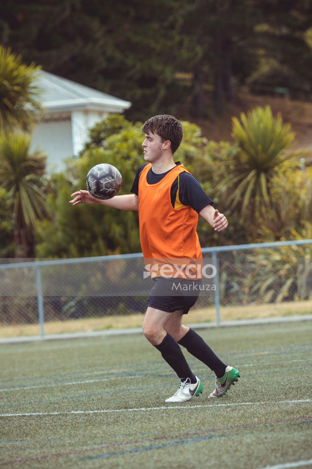 Football player in black shirt and orange scrimmage vest - Sports Zone sunday league