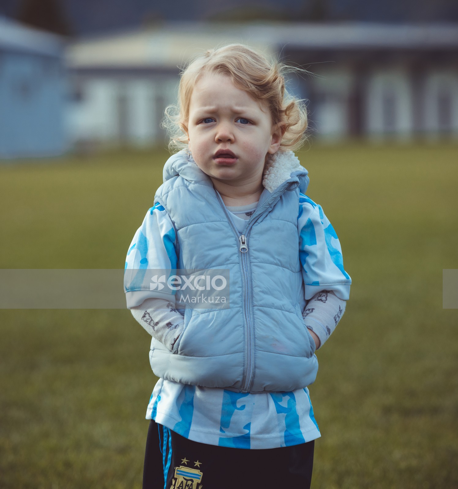 Cute little girl with hands in pockets at Little Dribblers football match