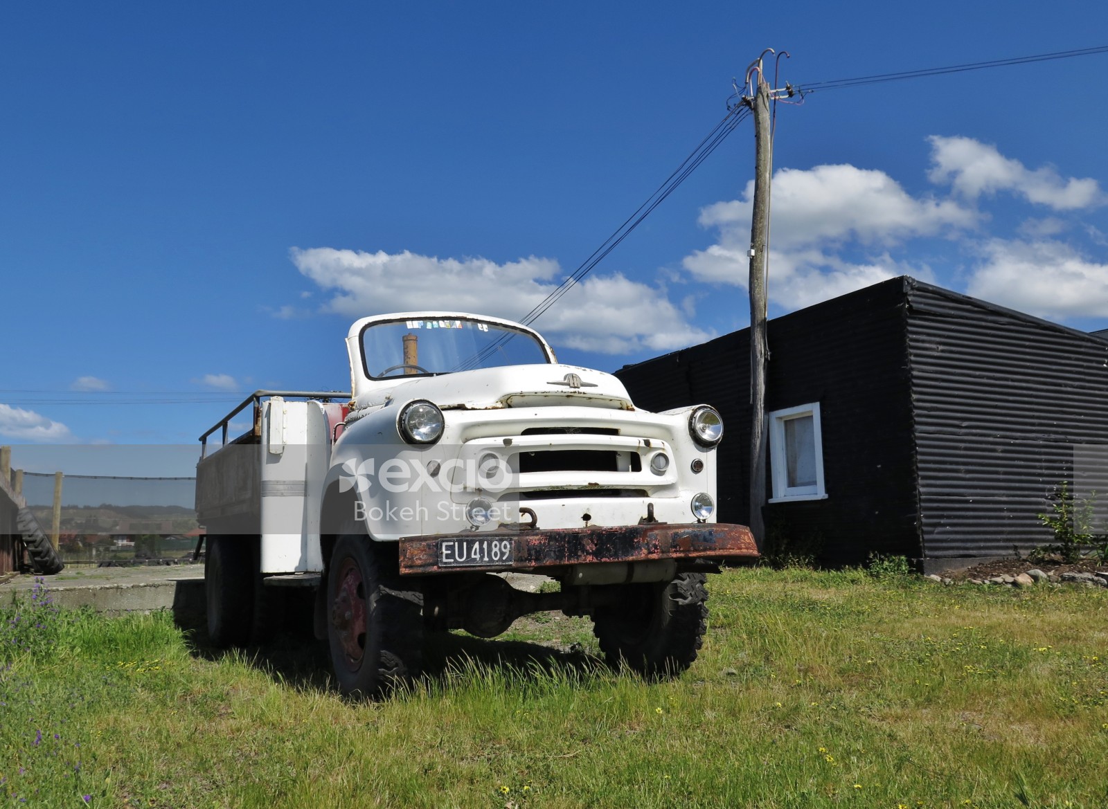 Old white roofless truck and a black shed at Hawkes bay