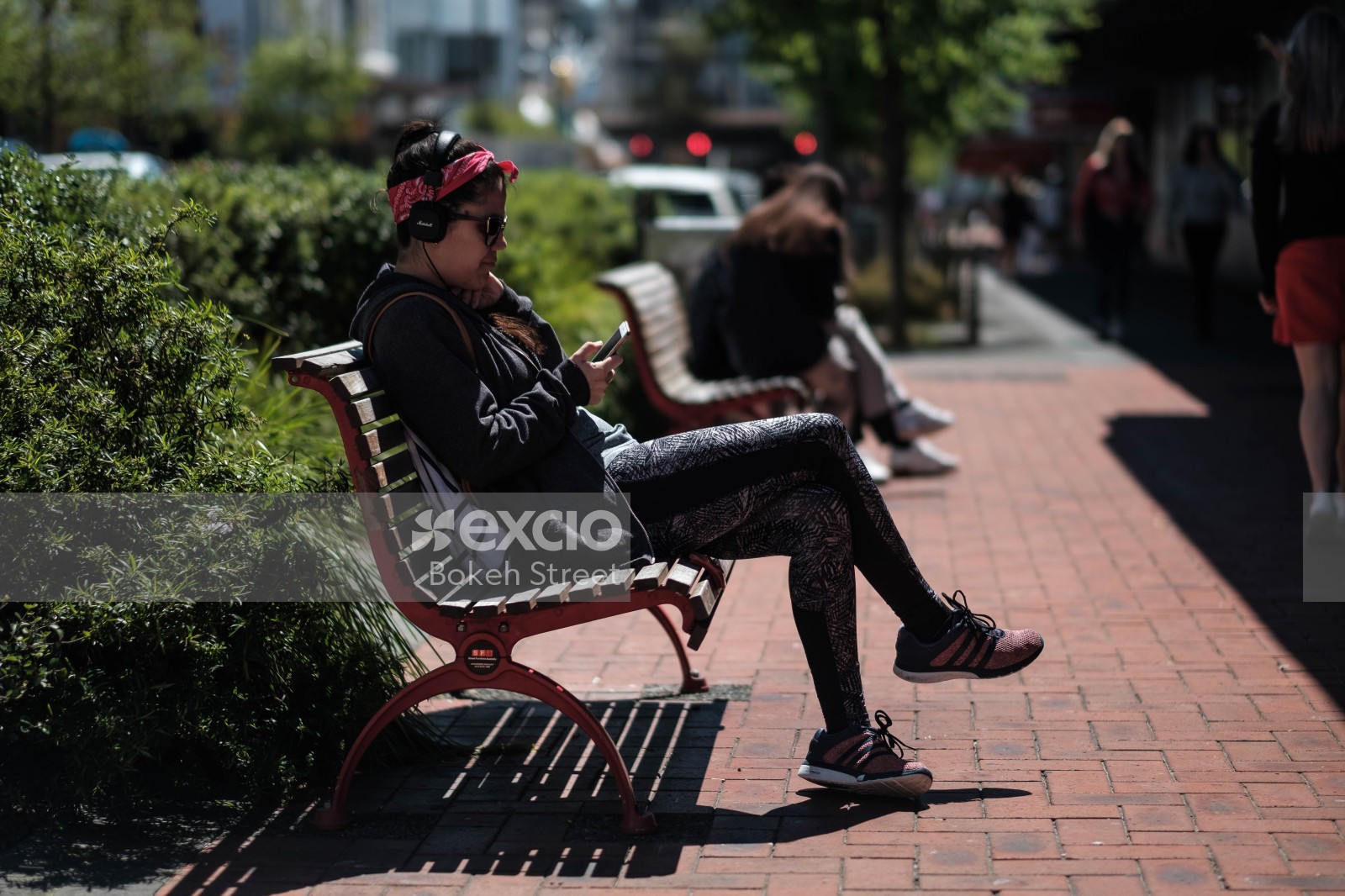 Woman sitting on a bench listening to music