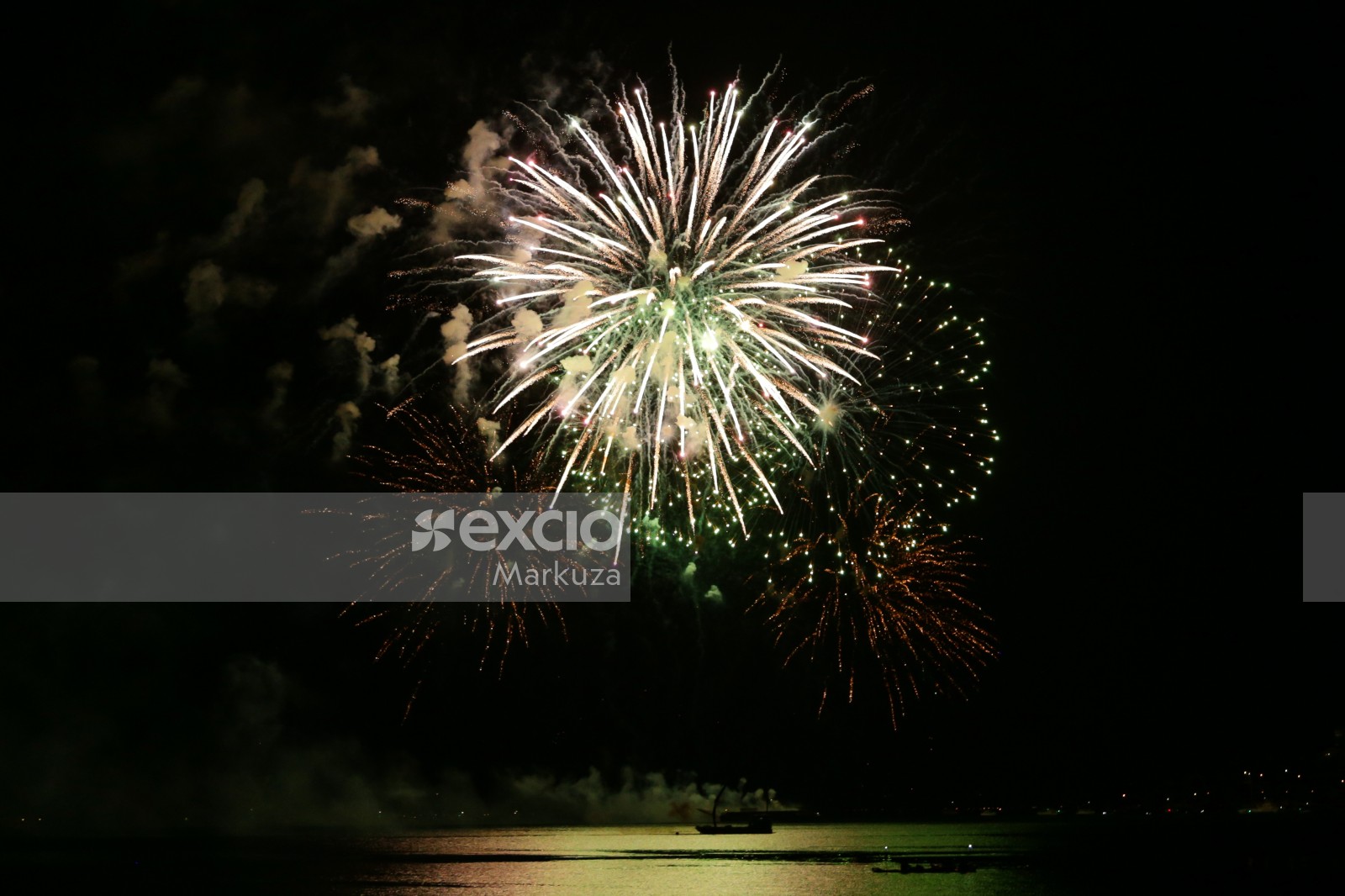 Bright fireworks and silhouette of ship in the water