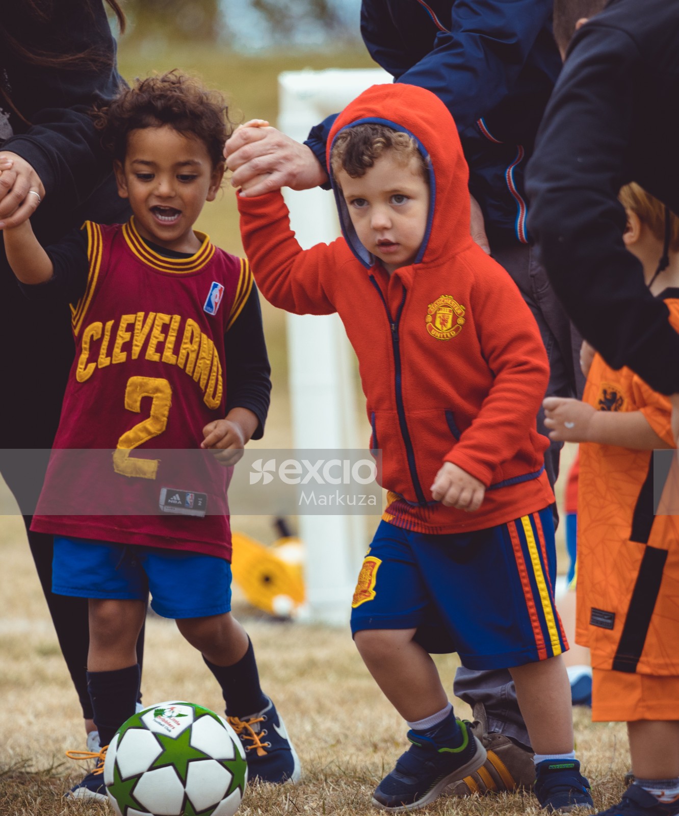 Kids in Manchester United and Cleveland NBA jersey at Little Dribblers football game