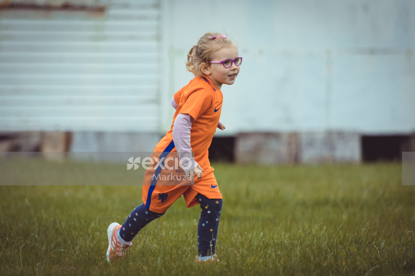 Girl with glasses and Nike Netherland kit running on grass - Little Dribblers