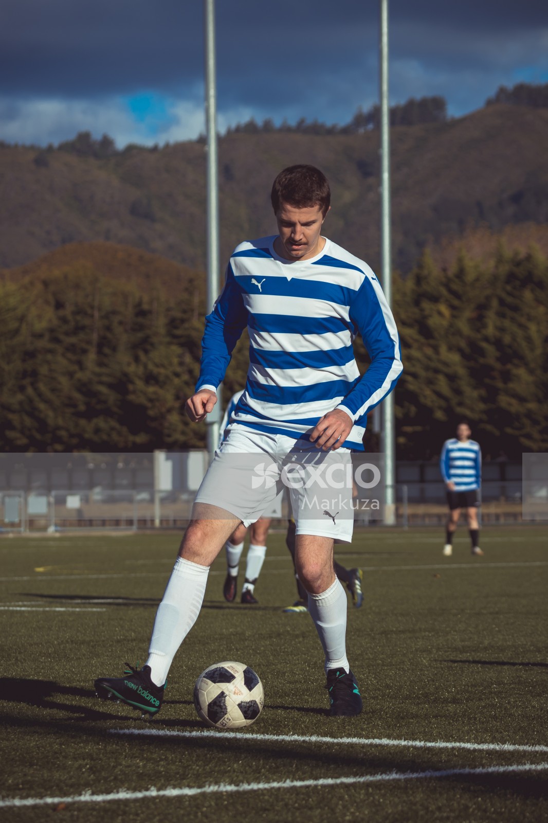 Player in a blue and white striped Puma shirt - Sports Zone sunday league