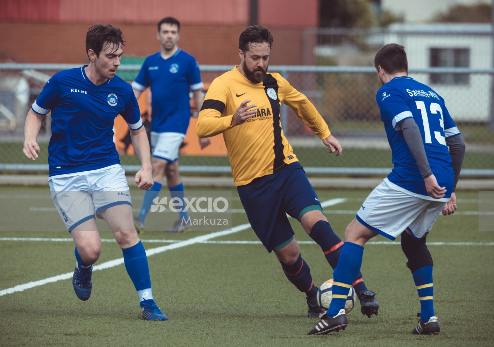 Bearded player in blue shorts dribbles through adversaries - Sports Zone sunday league
