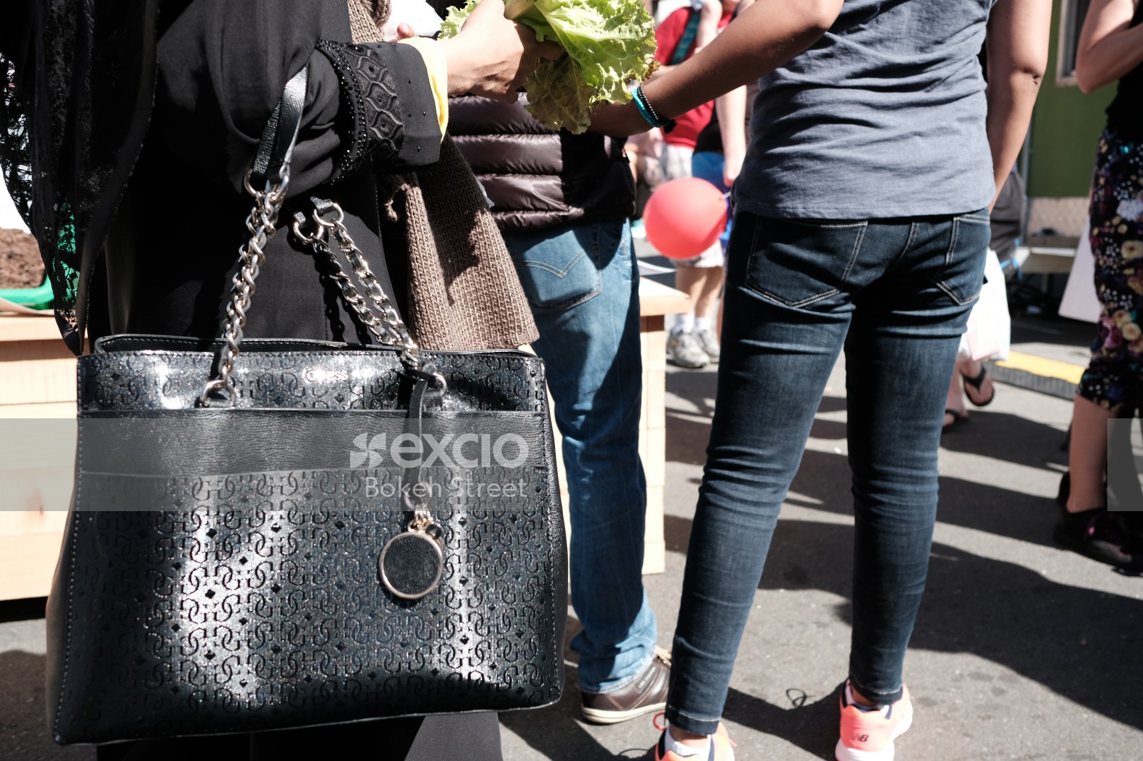 Woman carrying a handbag and salad leaves at Newtown festival 2021