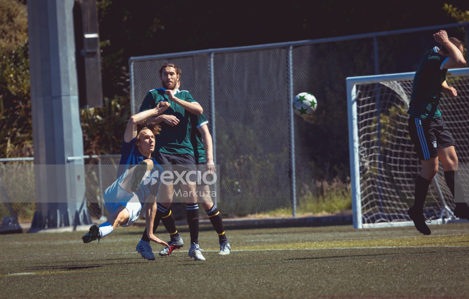 Player in blue shirt kicking football towards goal at Sports Zone sunday league