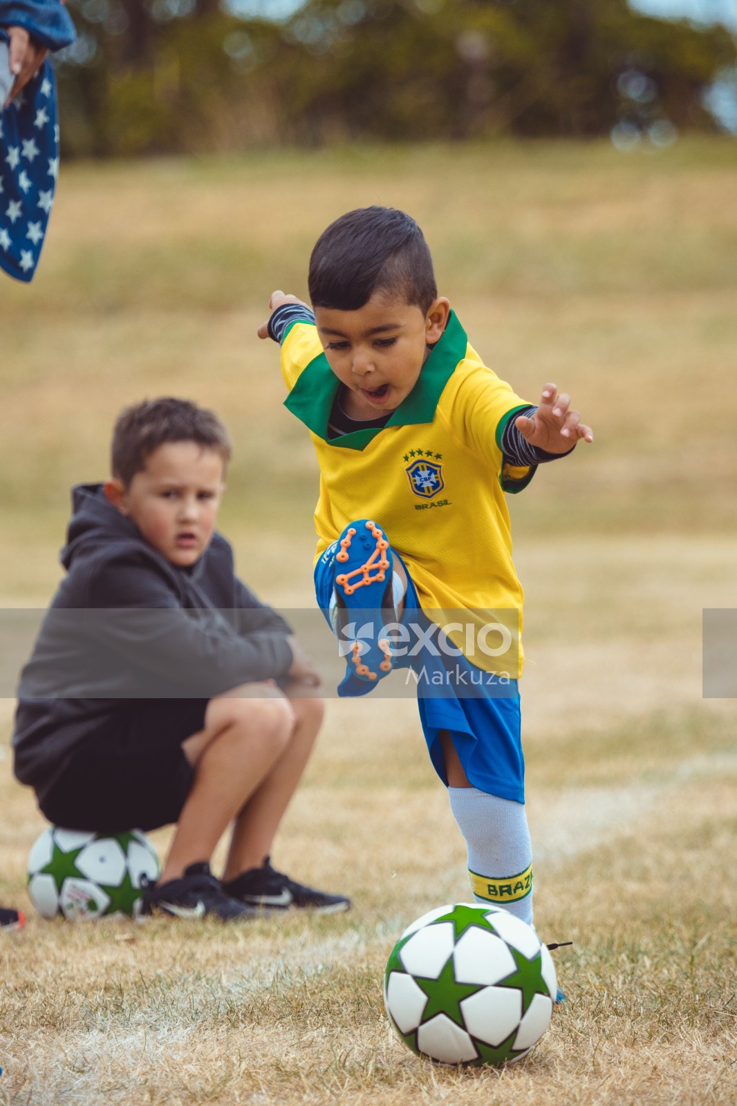 Boy in Brasil kit kicking football at Little Dribblers soccer game