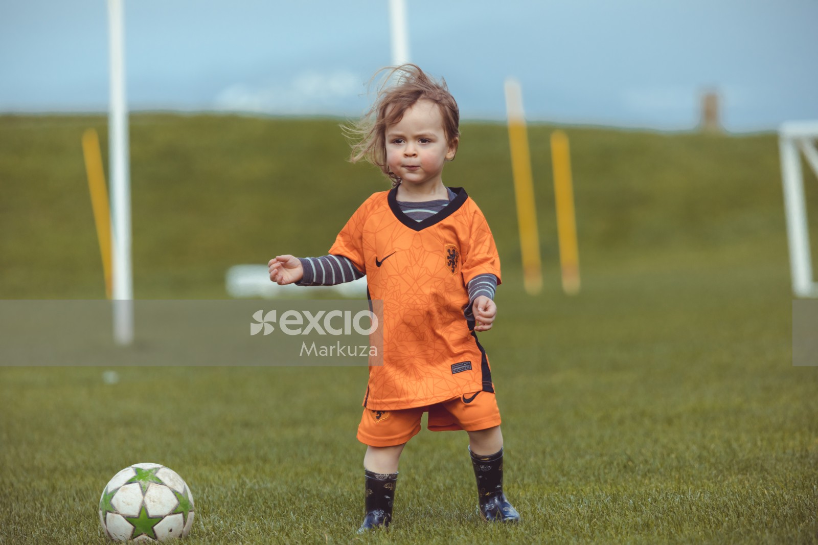 Little girl in orange kit at Little Dribblers sports feat