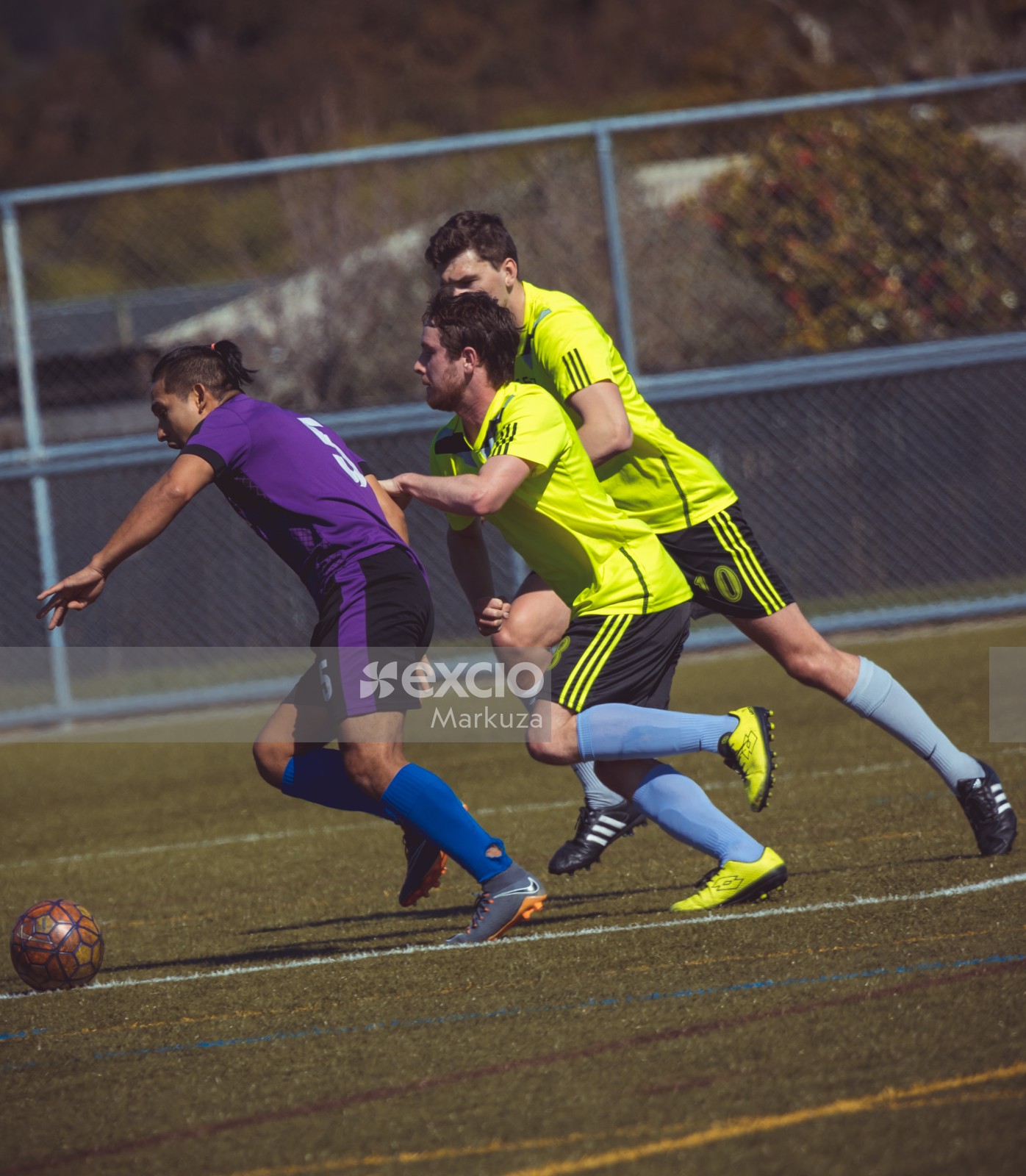 Two players in lime neon shirts try to tackle opponent - Sports Zone sunday league