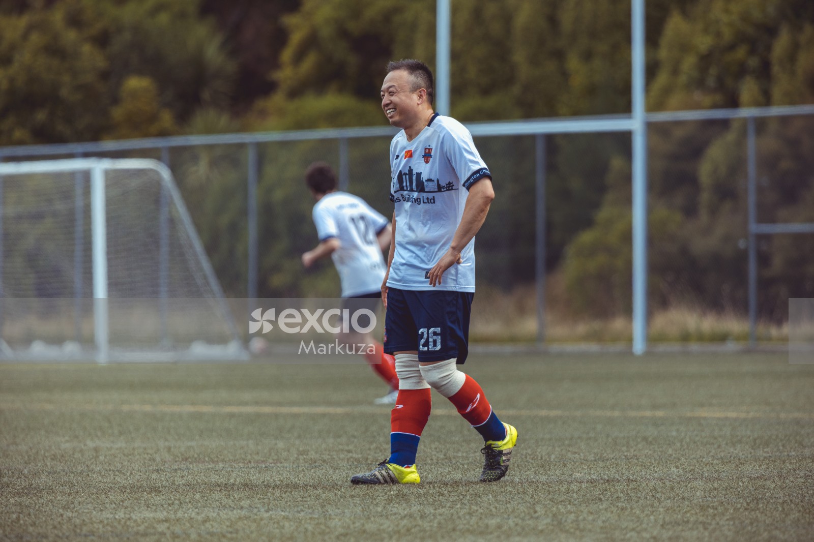 Middleaged asian player in white shirt laughing - Sports Zone sunday league