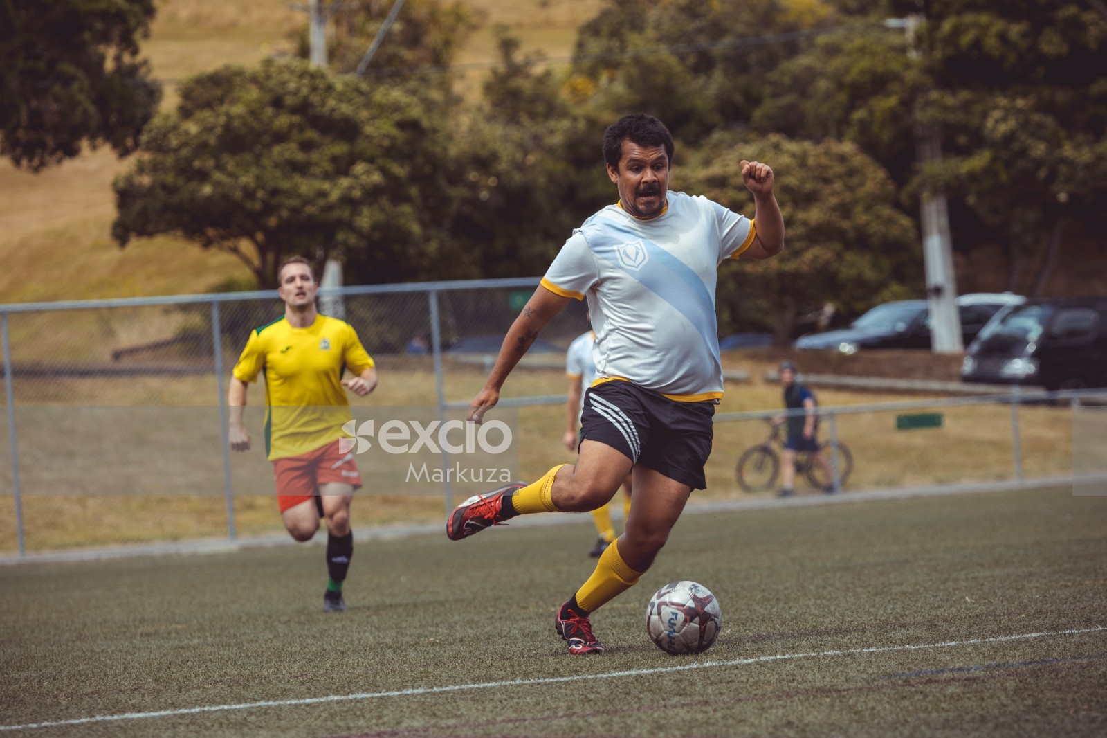 Football player in yellow socks running after ball - Sports Zone sunday league