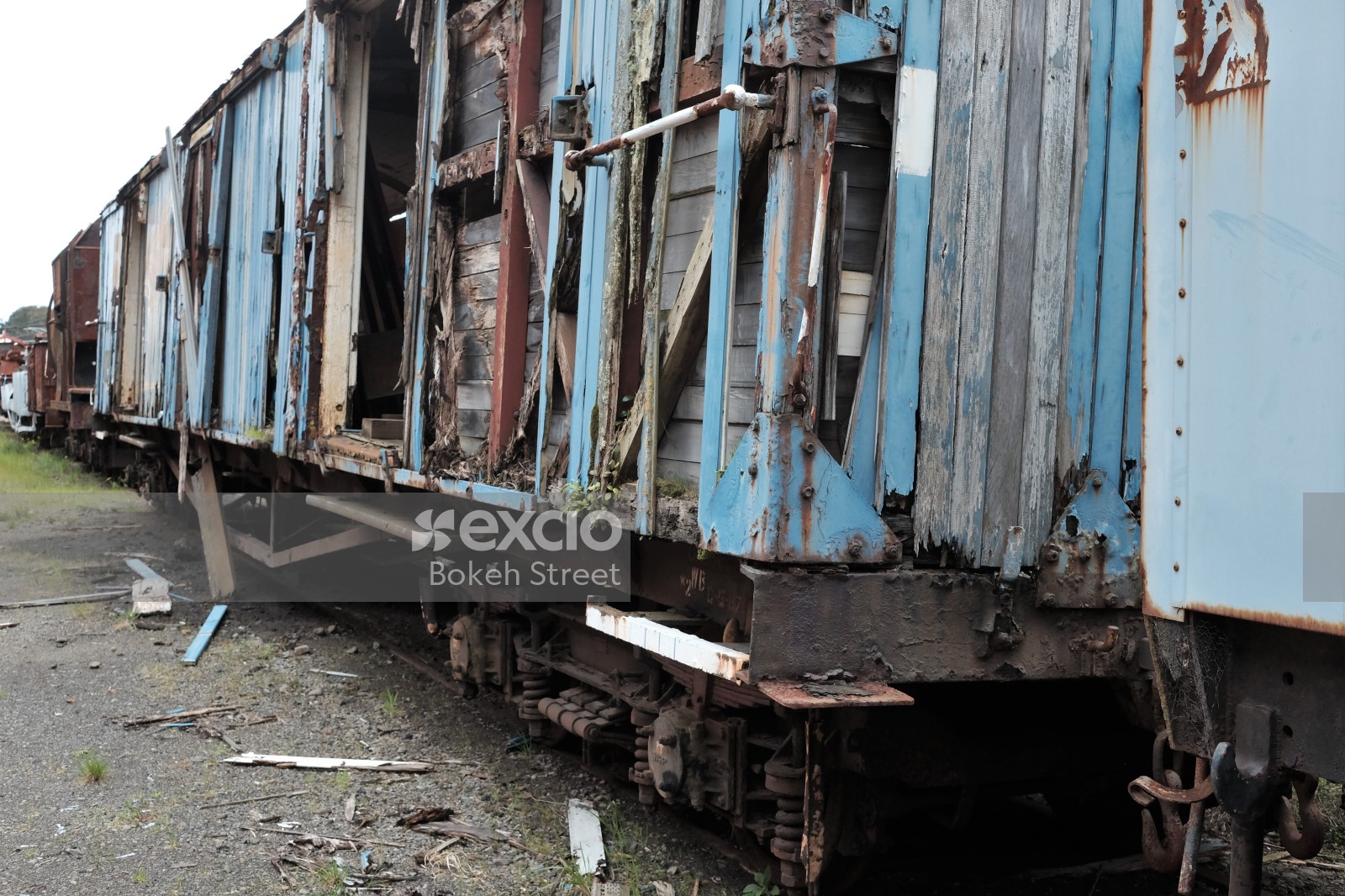 Damaged old wooden blue freight bogie on tracks