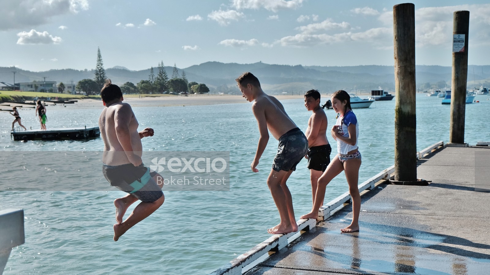 Kids diving into water from pier at Whanagamata