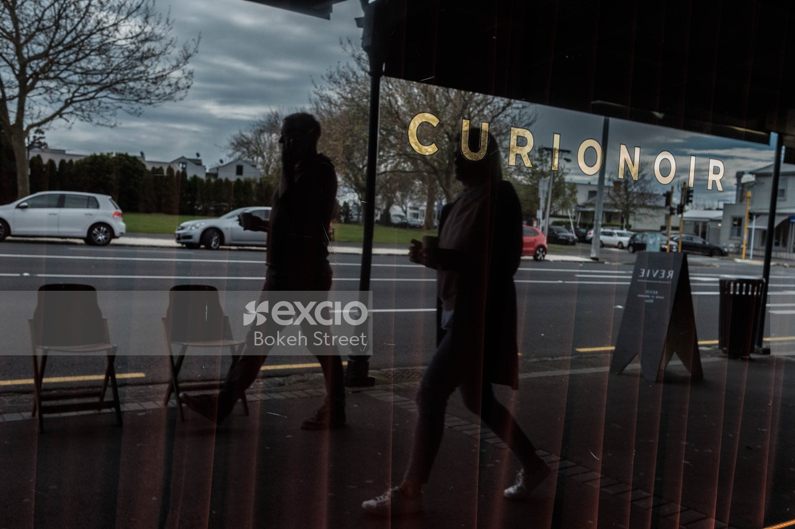 Reflection of people walking on the window of Curionoir shop