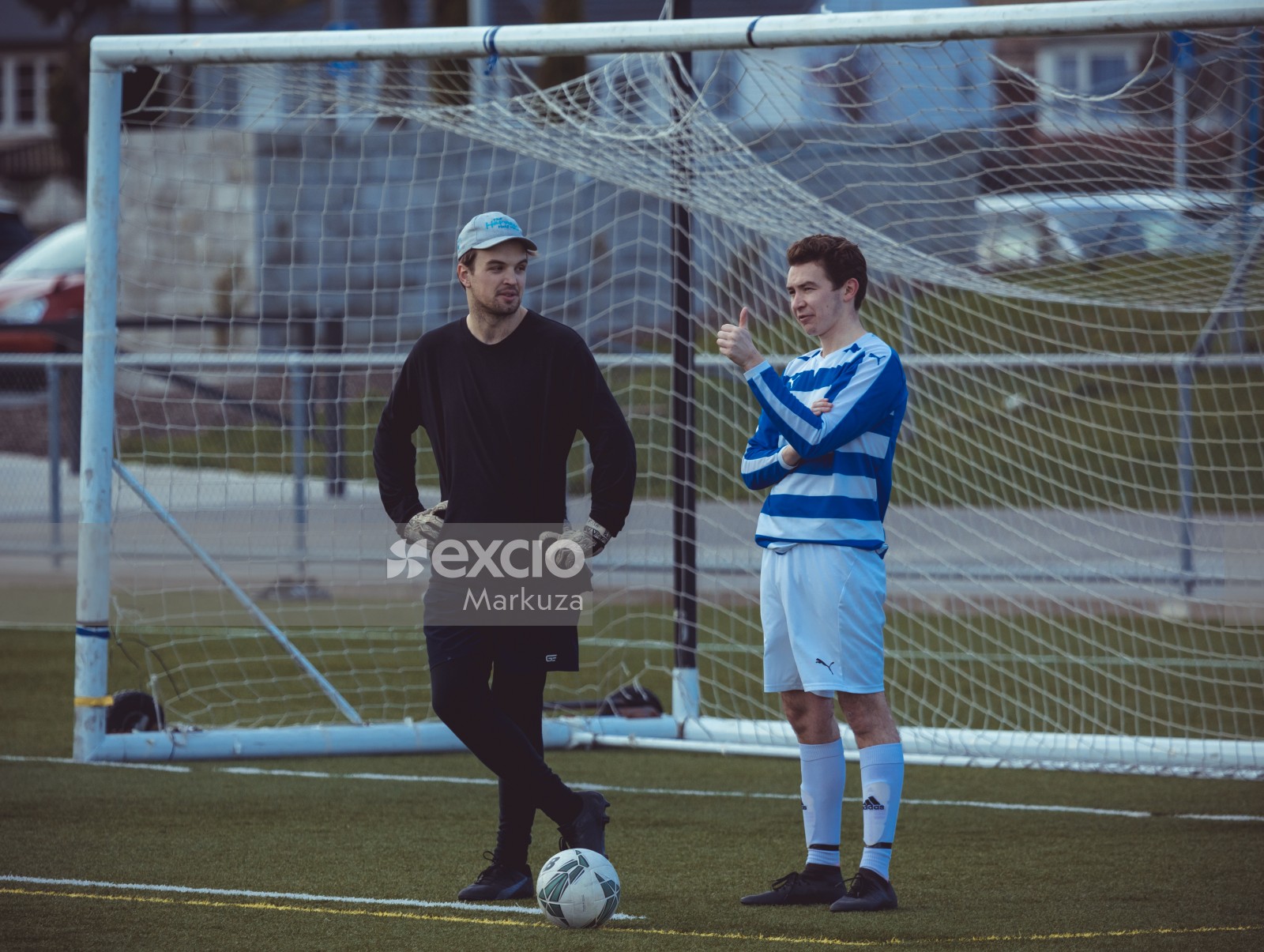 Player and goalkeeper standing at the goal post - Sports Zone sunday league