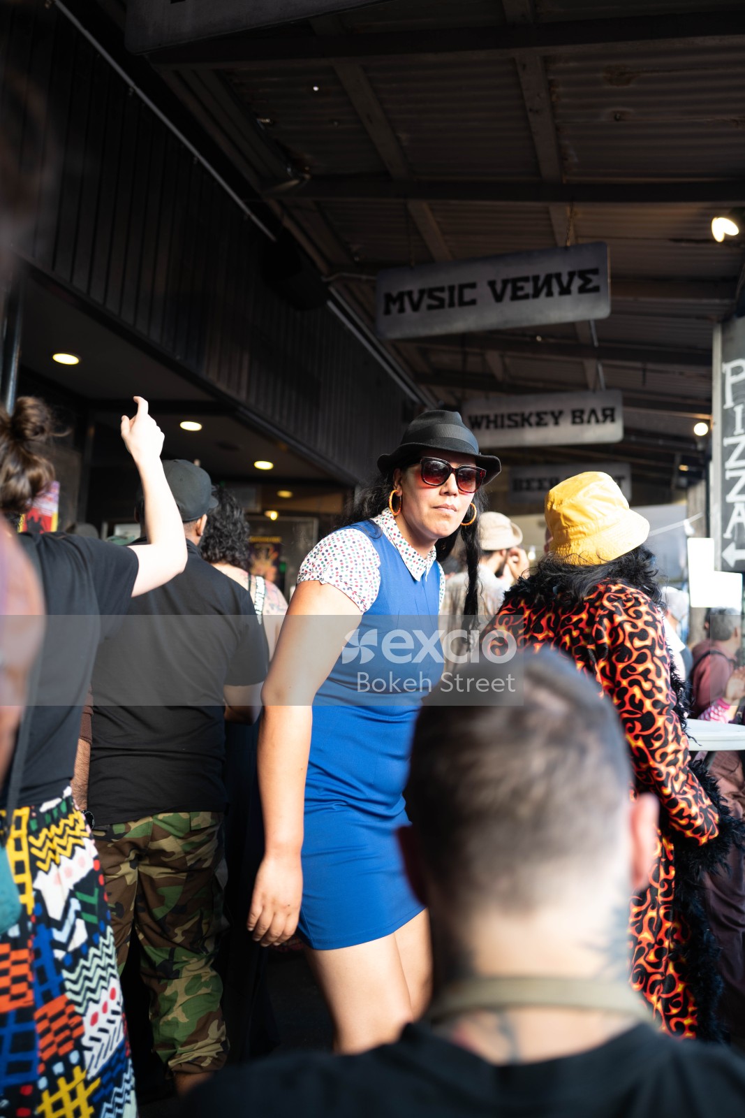 Woman wearing a polka dot blue dress and hat at Newtown festival 2021 bokeh