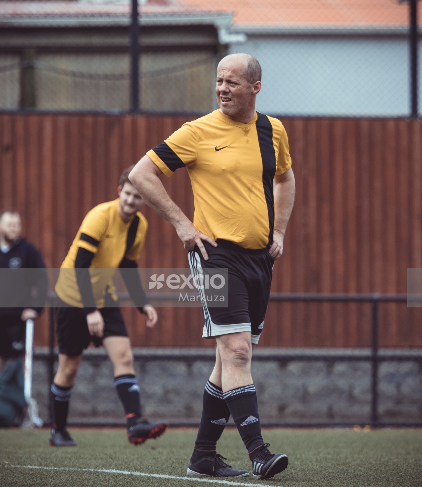 Bald soccer player looking back with arms on waist - Sports Zone sunday league