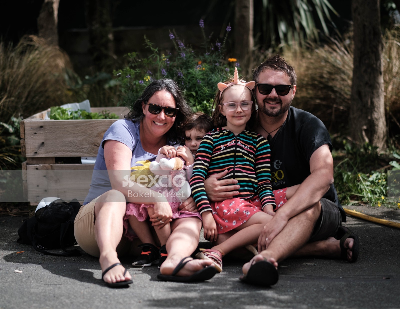 A family of four sitting on the ground at Aro valley Fair 2021
