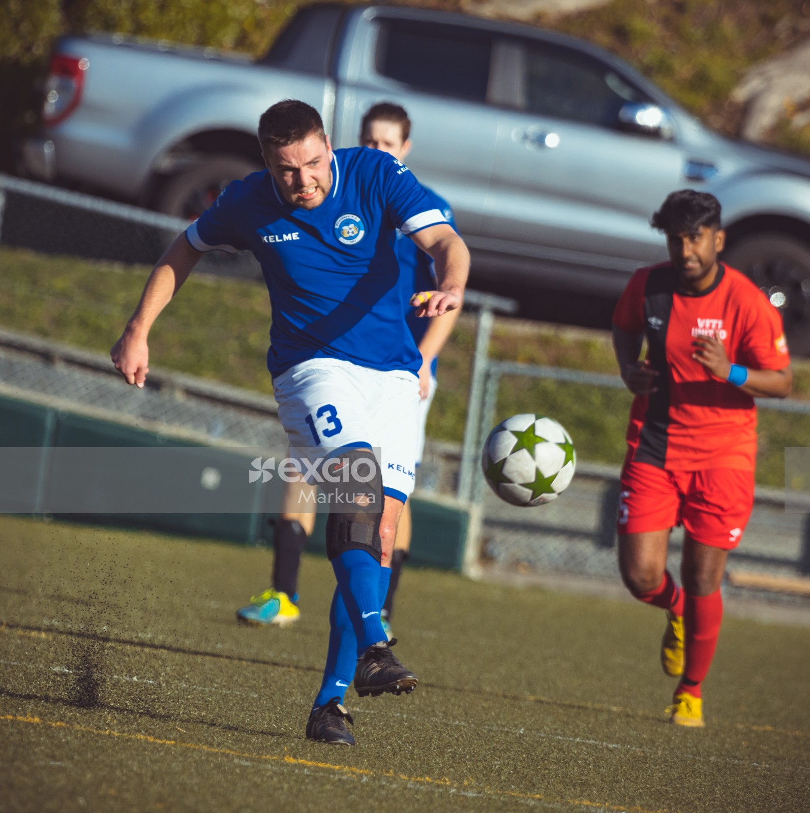 Player wearing blue Kelme shirt kicks football - Sports Zone sunday league