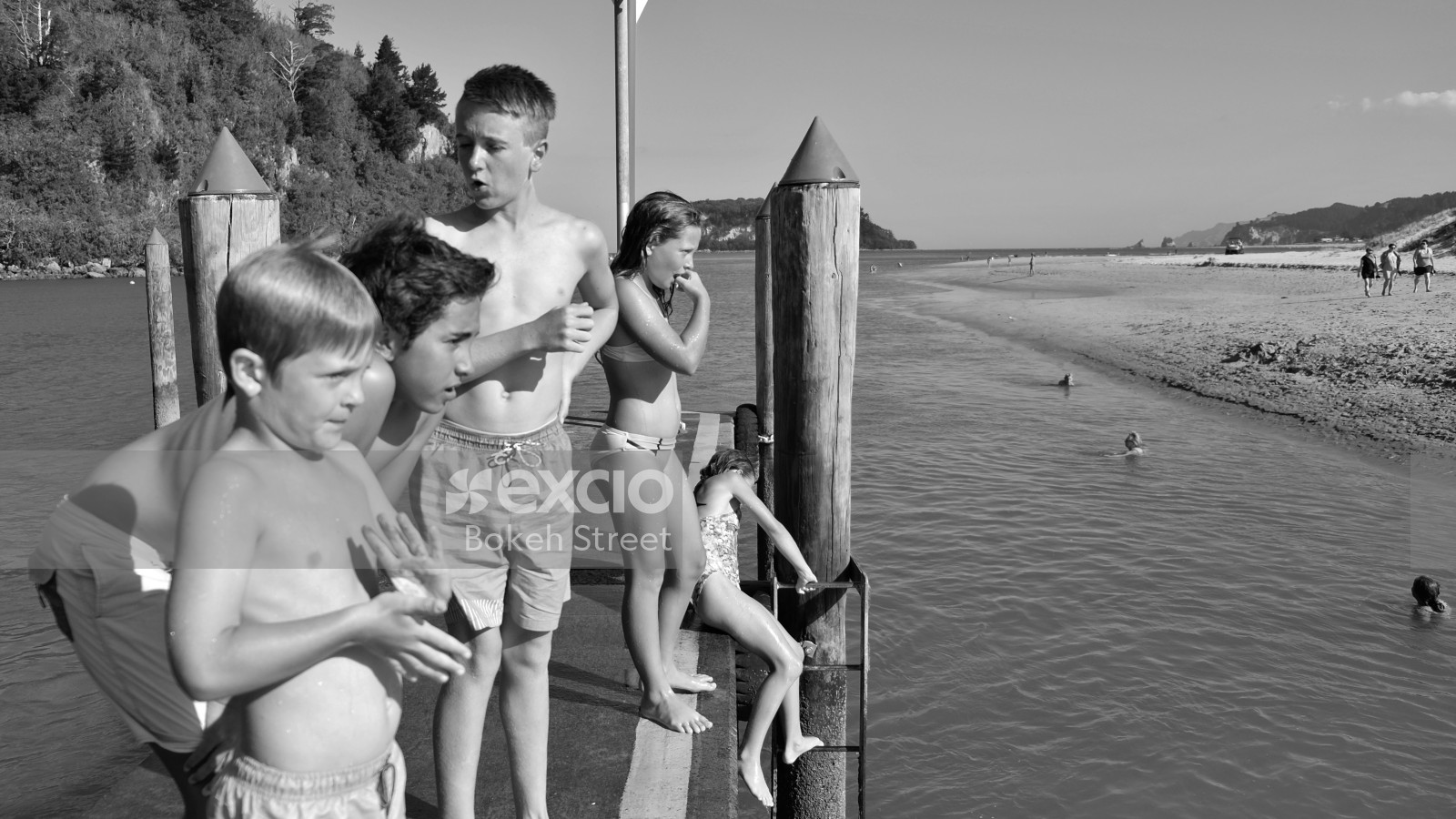 Boys and girls in swimsuit on a pier at Whanagamata black and white